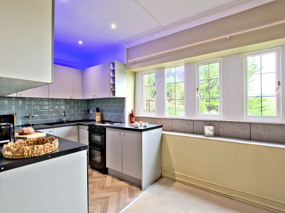 A kitchen with cabinets, a sink, and a stove at River View Cottage in Hanlith near Malham