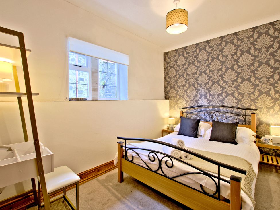 A bedroom with a bed and a lamp at River View Cottage in Hanlith near Malham