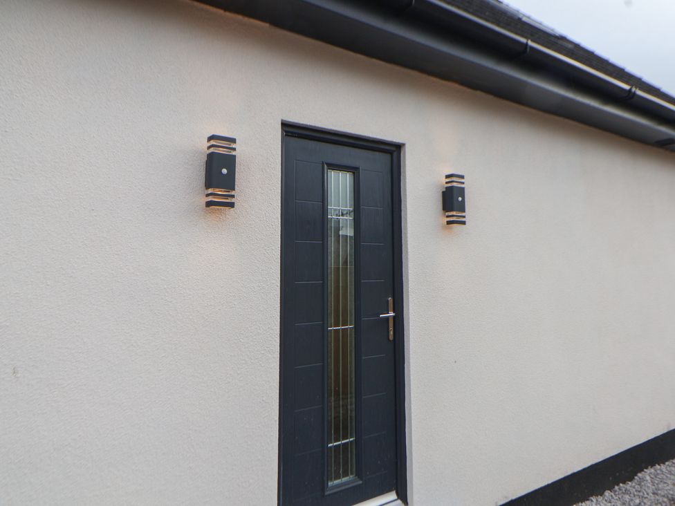 A door with light fixtures on the exterior at Mike’s Place in Rhyl