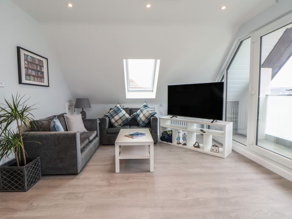 A living room with a sofa and television at Mike’s Place in Rhyl