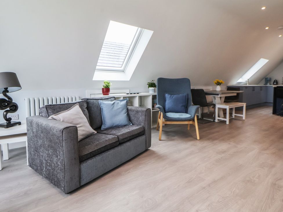 A living room with a sofa and armchair at Mike’s Place in Rhyl