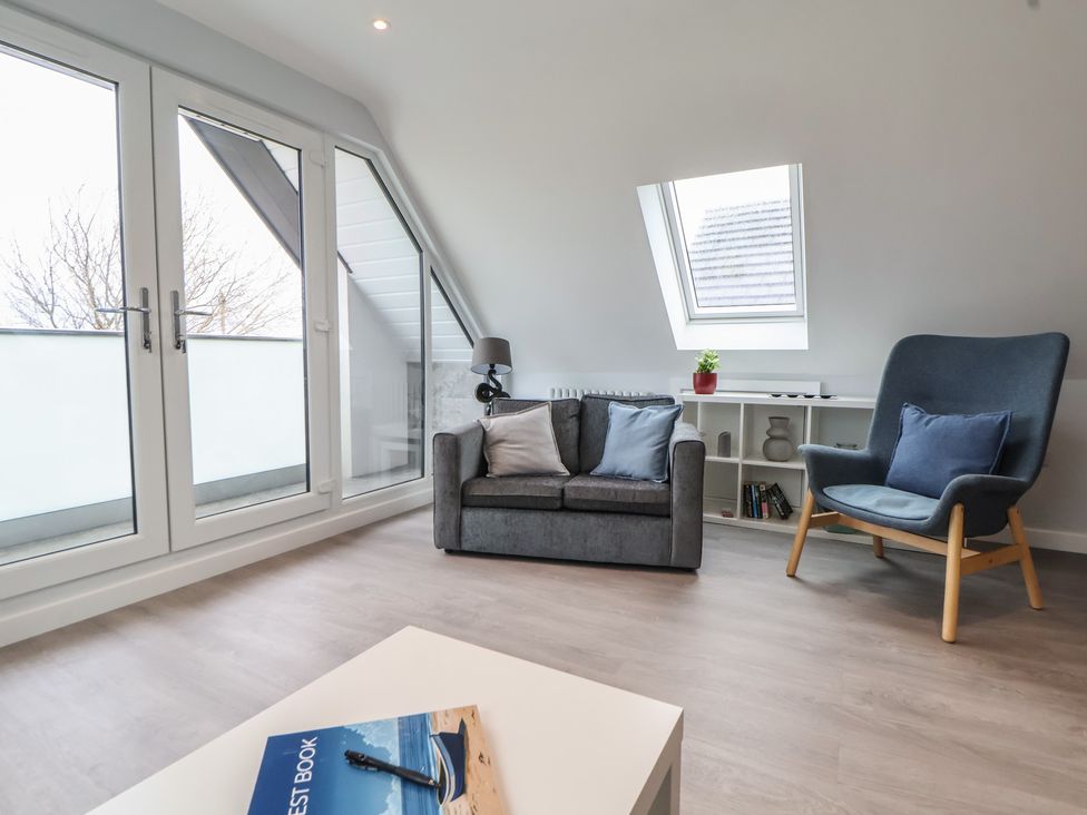 A living room with a sofa and armchair at Mike’s Place in Rhyl