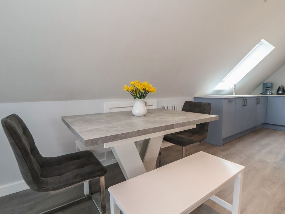 A kitchen with a table and chairs at Mike’s Place in Rhyl