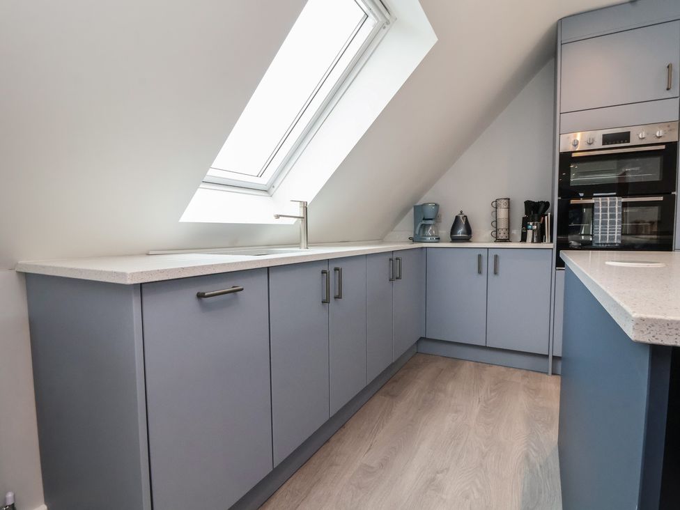 A kitchen with a sink and cabinets at Mike’s Place in Rhyl