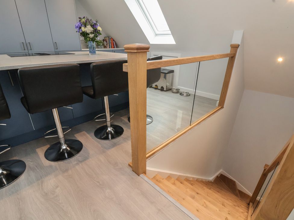 A kitchen with bar stools and a skylight at Mike’s Place in Rhyl