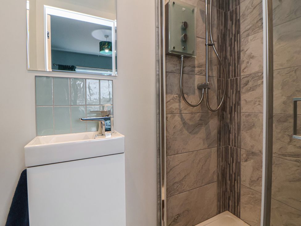 A bathroom featuring a sink and shower at Mike’s Place in Rhyl