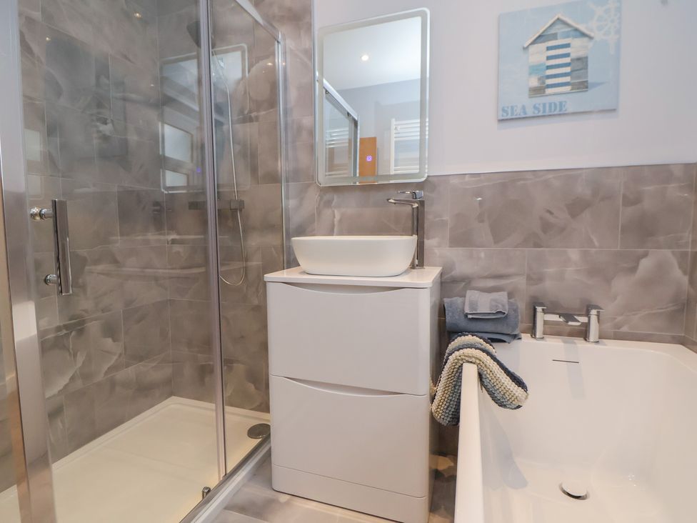 A bathroom with a shower and bathtub at Mike’s Place in Rhyl