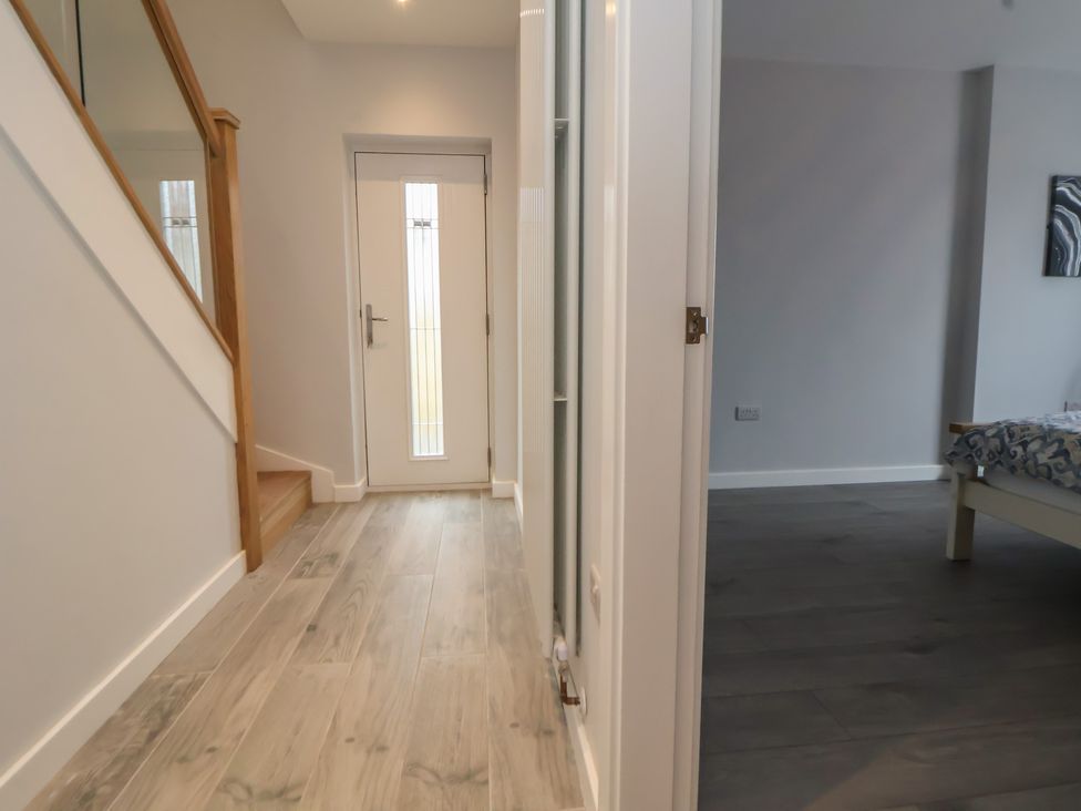 A hallway with a staircase and front door at Mike’s Place Rhyl