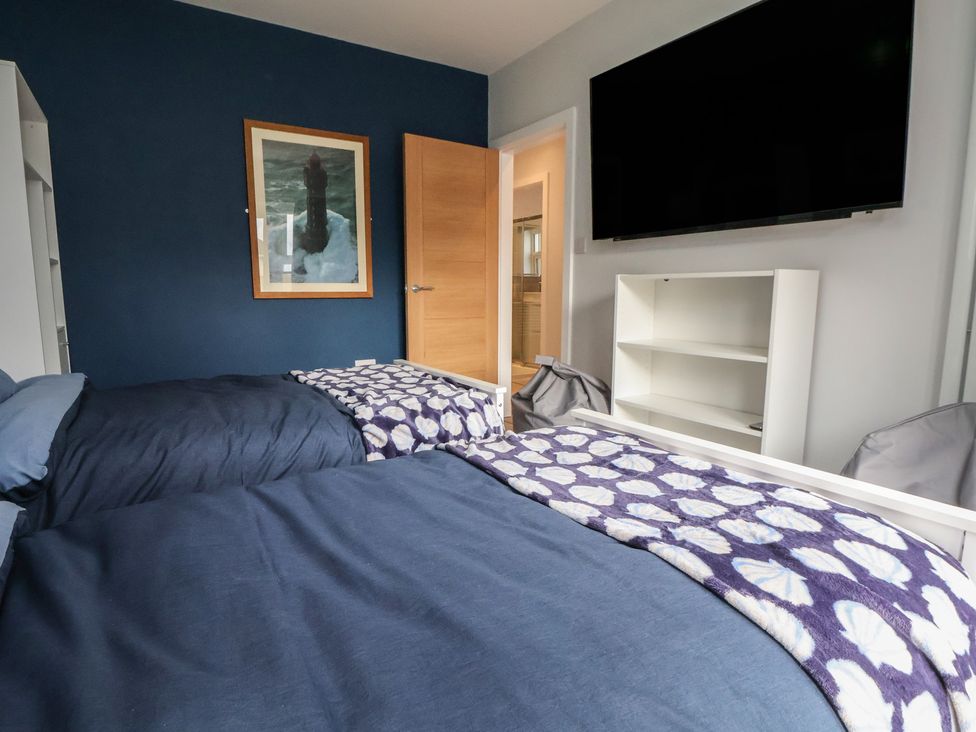 A bedroom with two beds and a television at Mike's Place in Rhyl