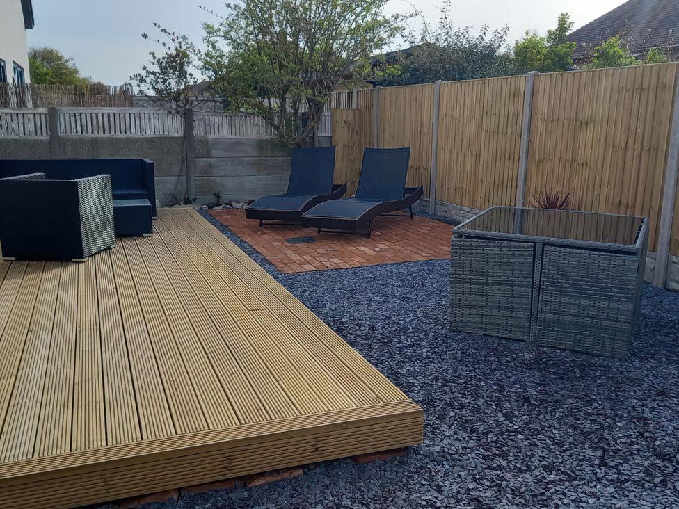A garden with lounge chairs and outdoor furniture at Mike’s Place On The Cove Rhyl