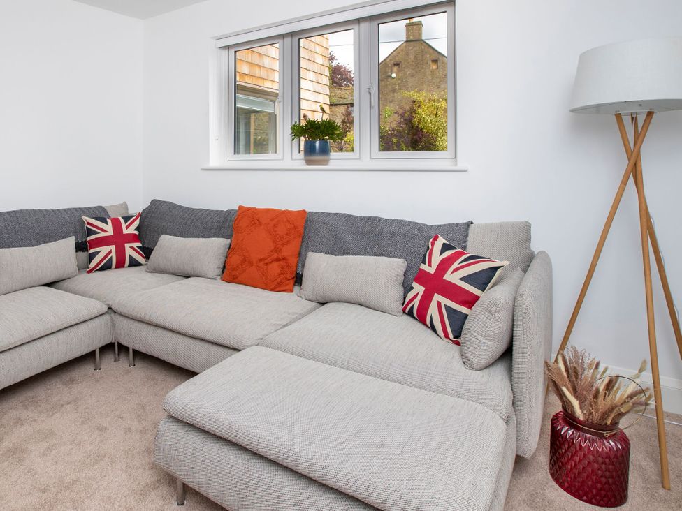A living room with a corner sofa and window at 2 The Croft in Skipton