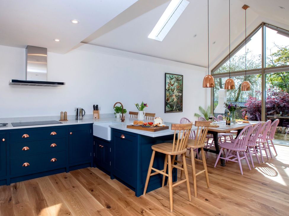 A kitchen with blue cabinetry and a dining area at 2 The Croft Skipton