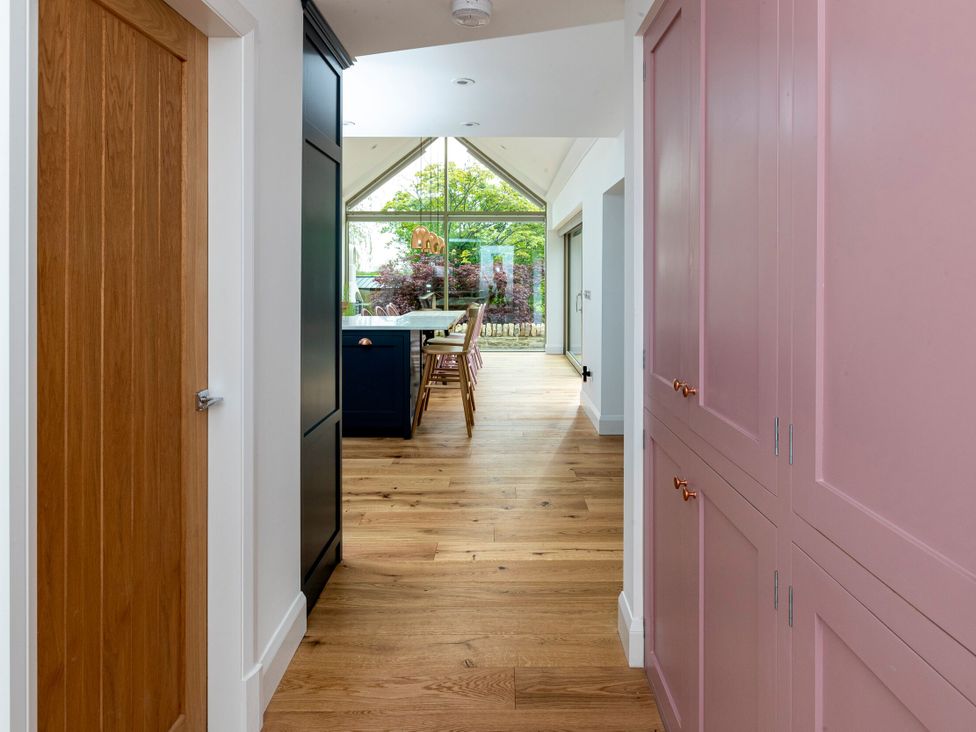 A hallway leading to a kitchen with dining table and chairs at 2 The Croft in Skipton