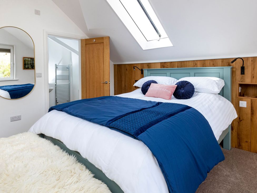 A bedroom with a bed and mirror at 2 The Croft in Skipton