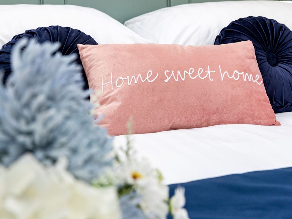 A bed with pillows and a cushion at 2 The Croft in Skipton