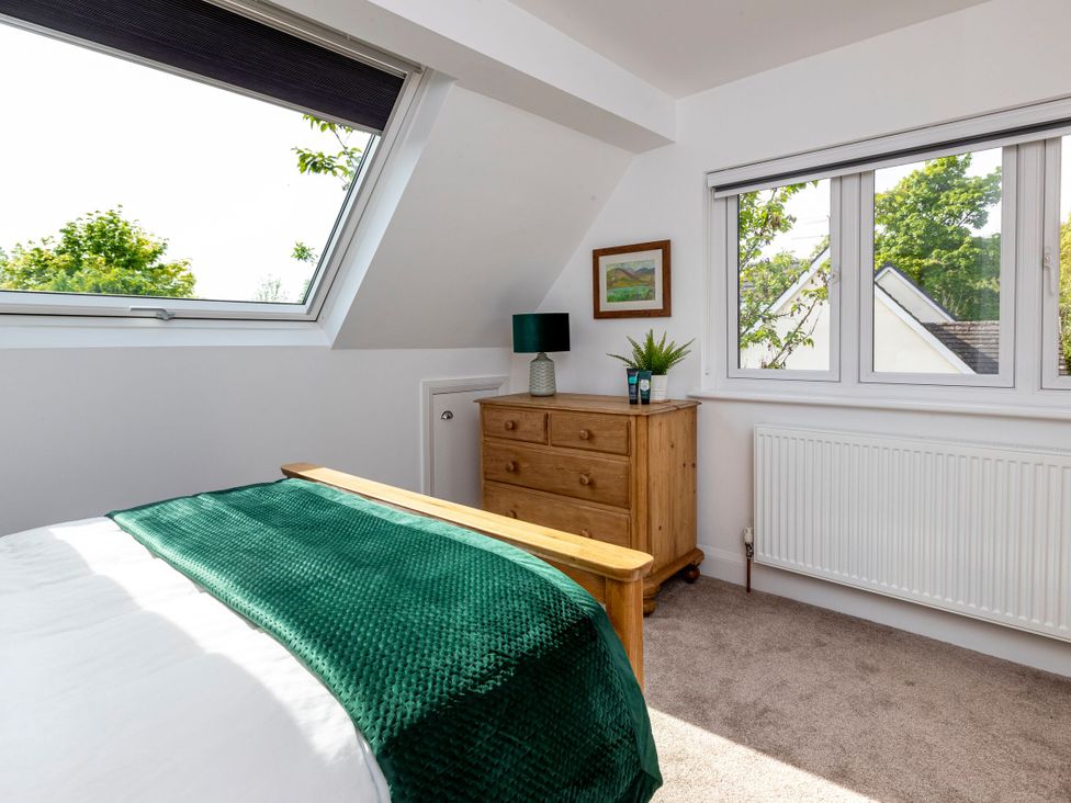 A bedroom with a bed and dresser near windows at 2 The Croft in Skipton