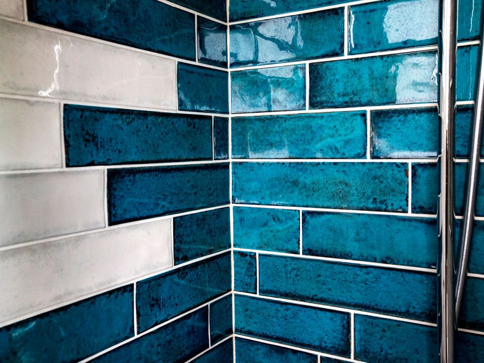 A bathroom wall with blue and white tiles at 2 The Croft in Skipton