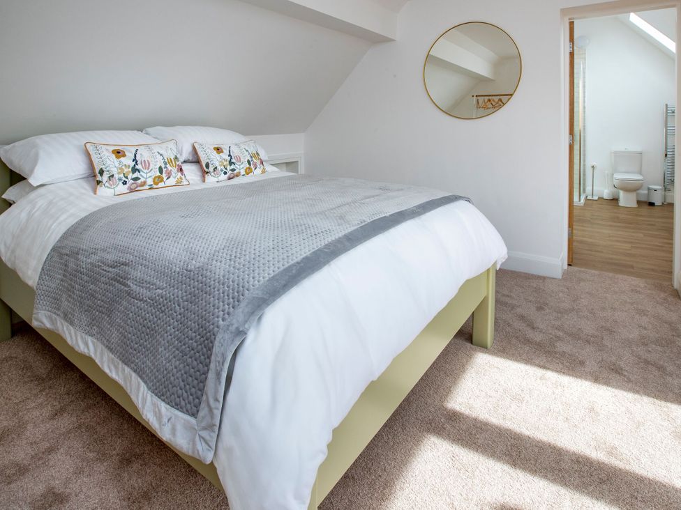 A bedroom with a bed and an adjoining bathroom at 2 The Croft in Skipton