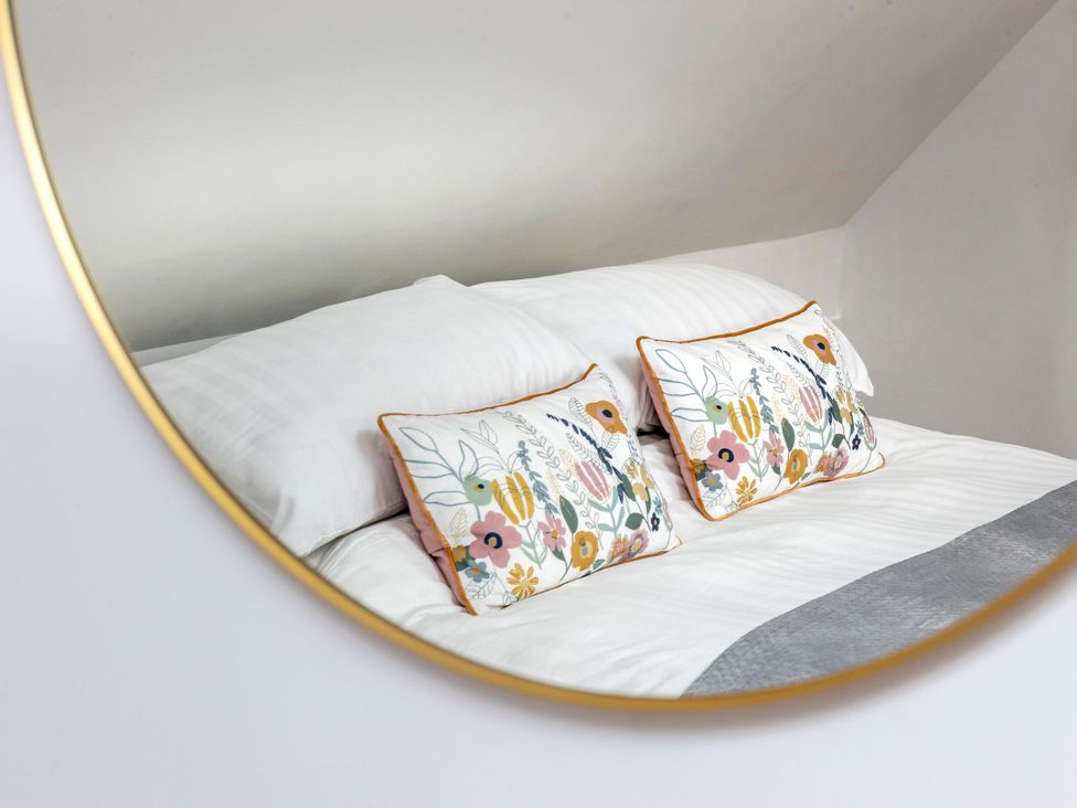 A bed with pillows and decorative cushions at 2 The Croft in Skipton