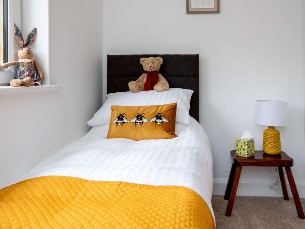 A bedroom with a bed and a teddy bear at 2 The Croft in Skipton
