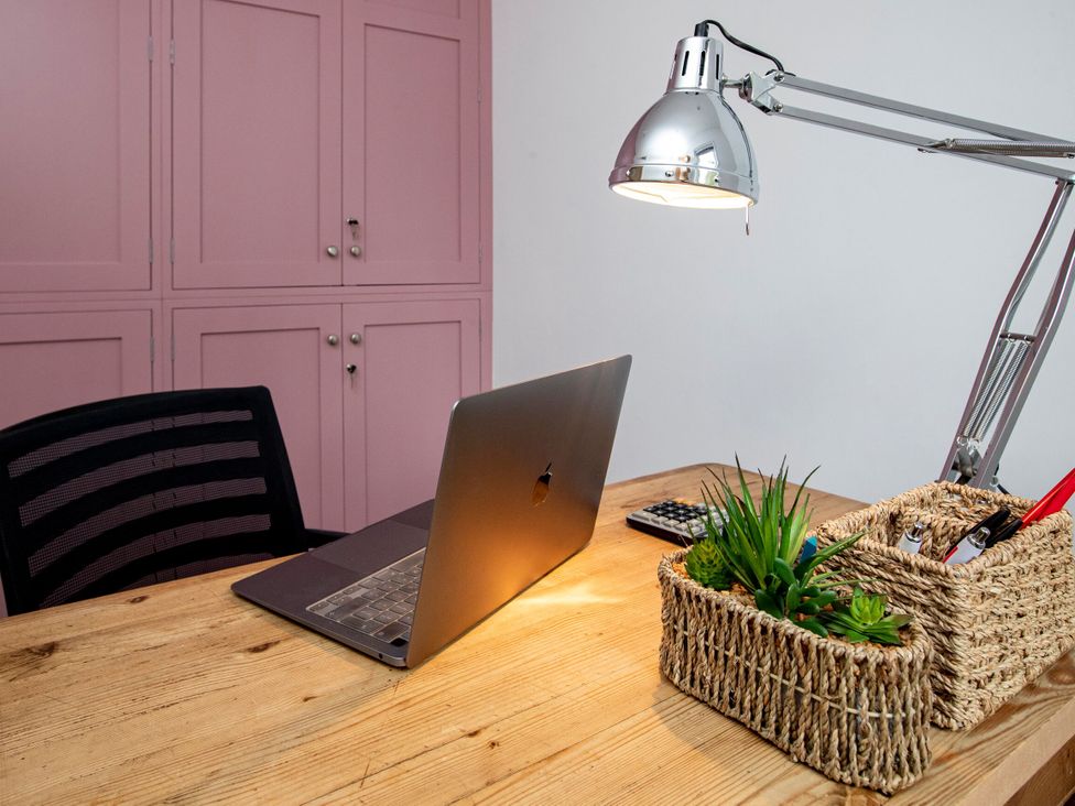 An office with a laptop, desk, chair, and lamp at 2 The Croft in Skipton