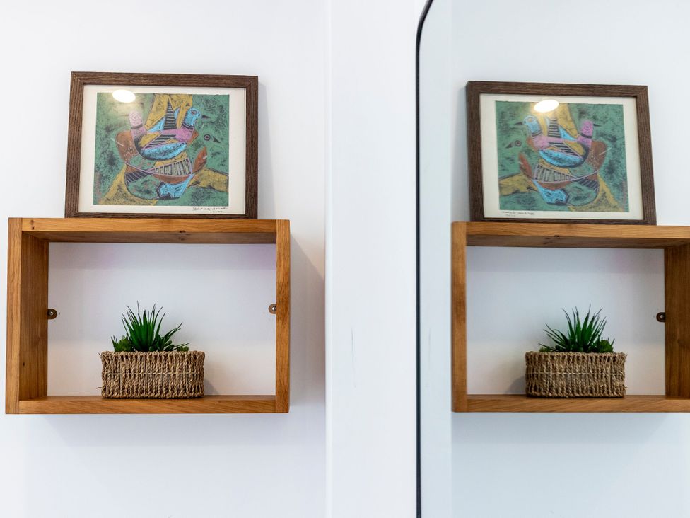 A shelf with a framed artwork and a plant at 2 The Croft Skipton