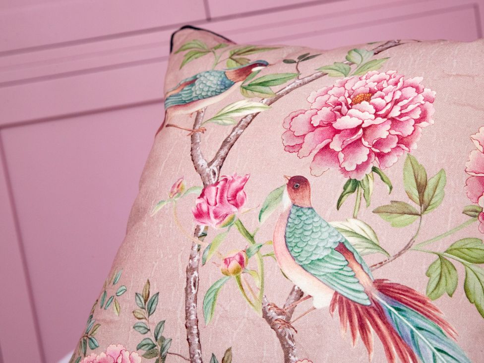 A decorative cushion with bird and flower patterns at 2 The Croft in Skipton