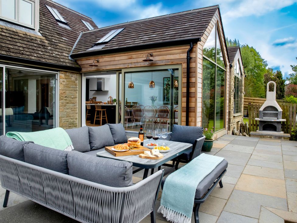 An outdoor seating area with a couch and table at 2 The Croft Skipton