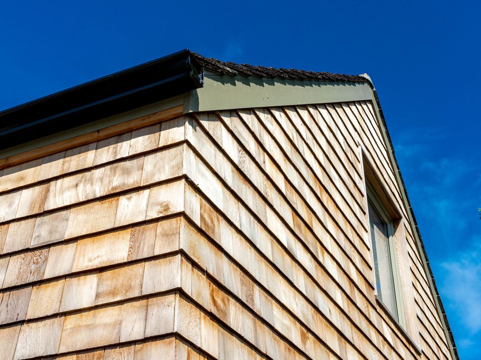 A building with wooden siding and a window at 2 The Croft Skipton