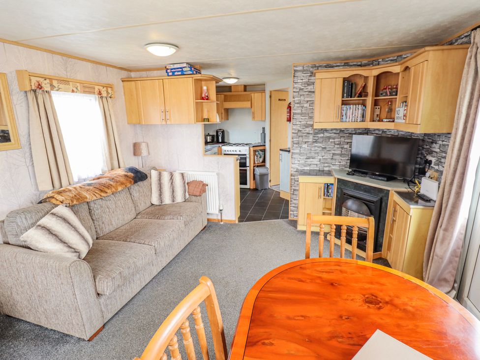 A living room with a sofa and dining area at The Promenade in Skegness