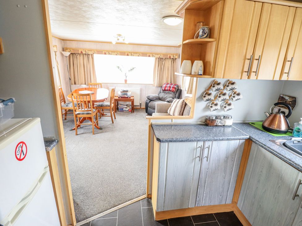 A kitchen view into a dining area and living space at The Promenade in Skegness