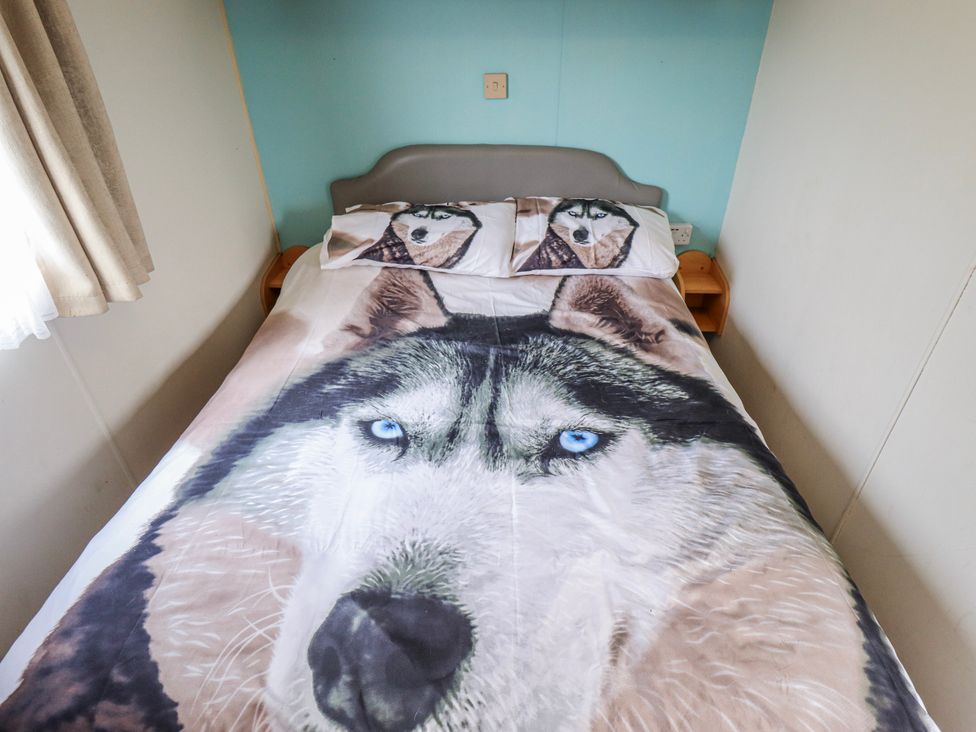 A bedroom with a bed featuring a wolf design bedspread and pillows at The Promenade in Skegness