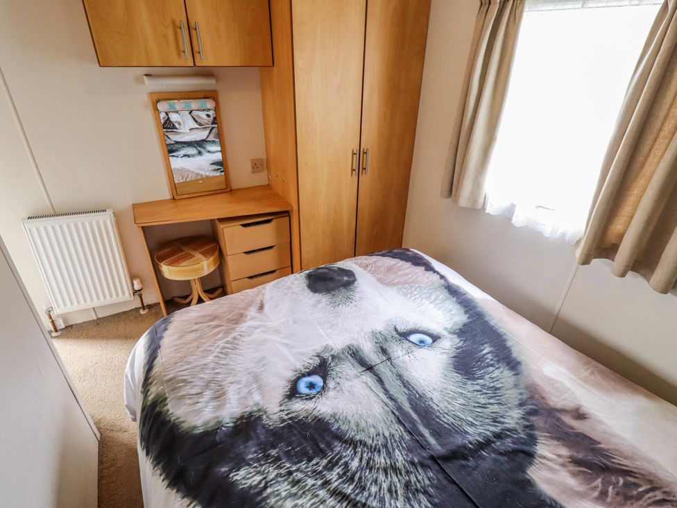 A bedroom with a bed and wardrobe at The Promenade in Skegness