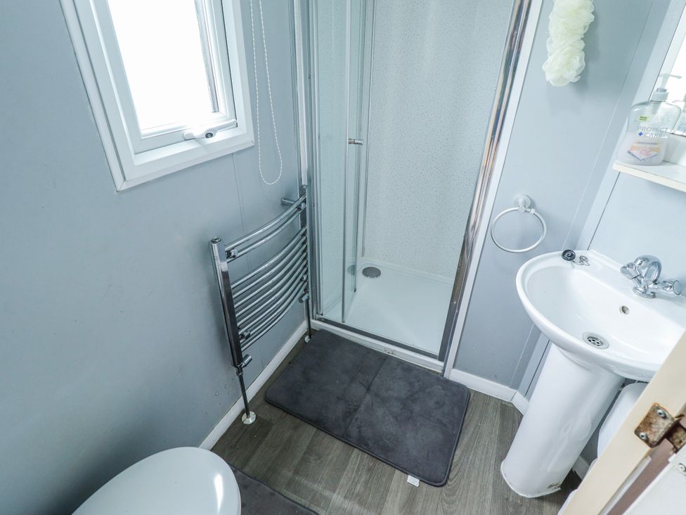 A bathroom with a shower, sink, and toilet at The Promenade in Skegness