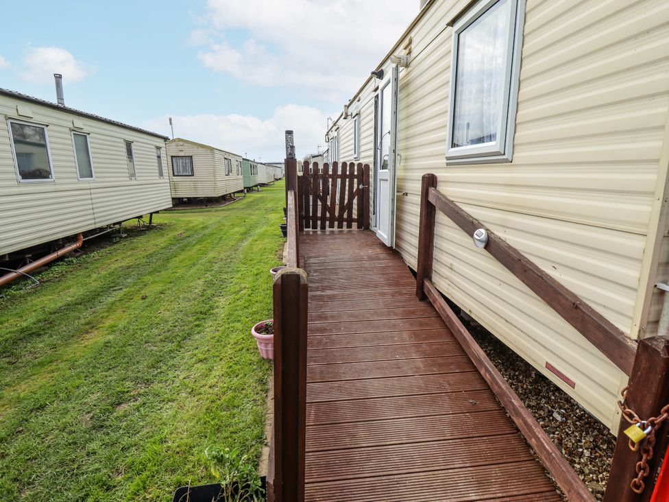 A deck leading to a caravan with a flower pot at The Promenade in Skegness
