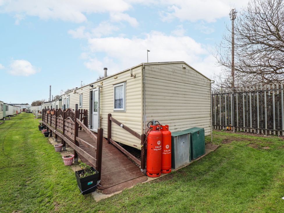 A caravan with wooden decking and gas bottles at The Promenade in Skegness