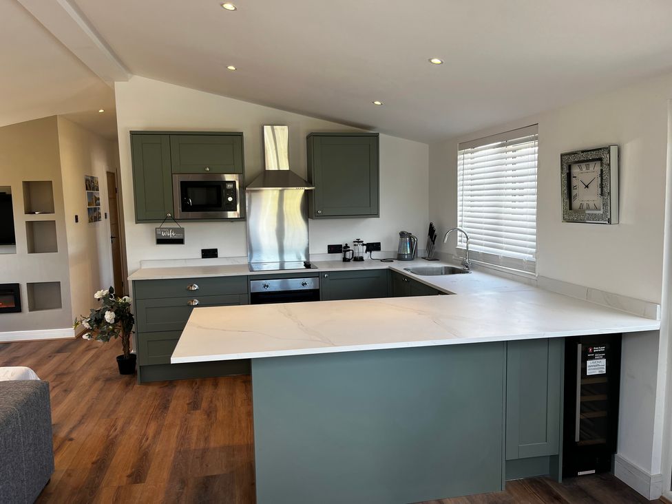 A kitchen with a countertop, refrigerator, and microwave at Meadow View Cottage in Gloucester