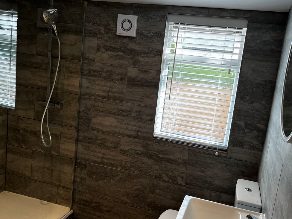 A bathroom with a shower, toilet, and sink at Meadow View Cottage in Gloucester