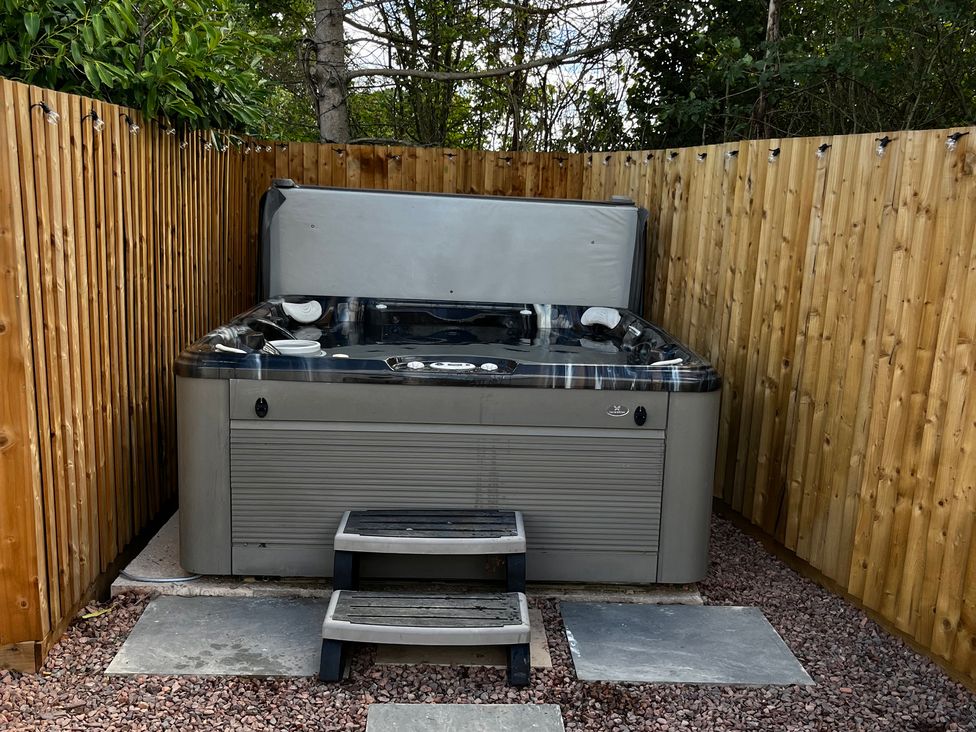 A hot tub with steps in an outdoor area at Meadow View Cottage in Gloucester