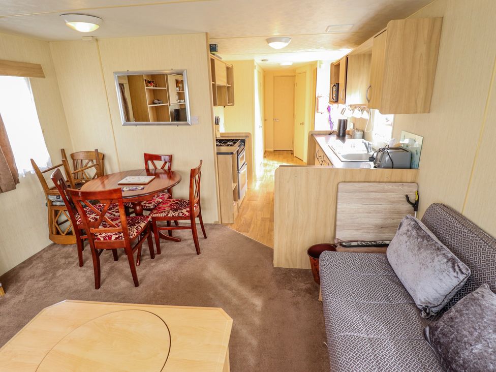 A living room with a dining table and kitchen area at Seaview in Skegness