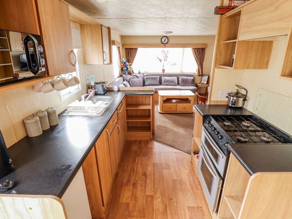 A kitchen area with stove, sink, and seating area at Seaview in Skegness