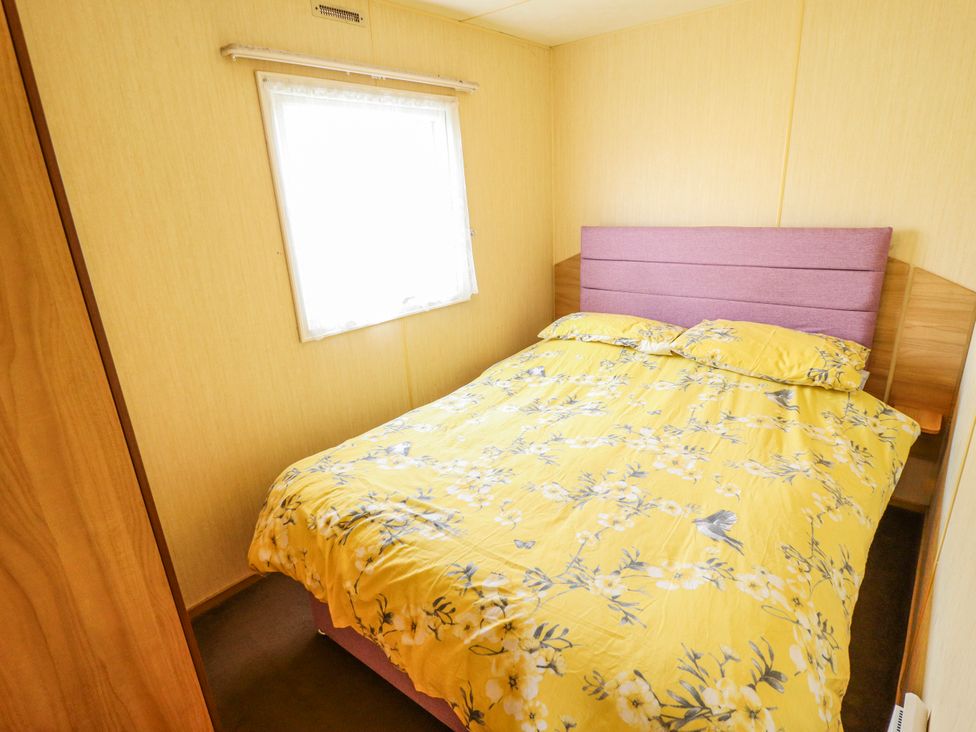 A bedroom with a bed and window at Seaview in Skegness