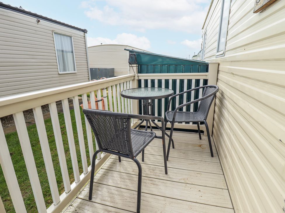 A balcony with a table and chairs at Seaview in Skegness