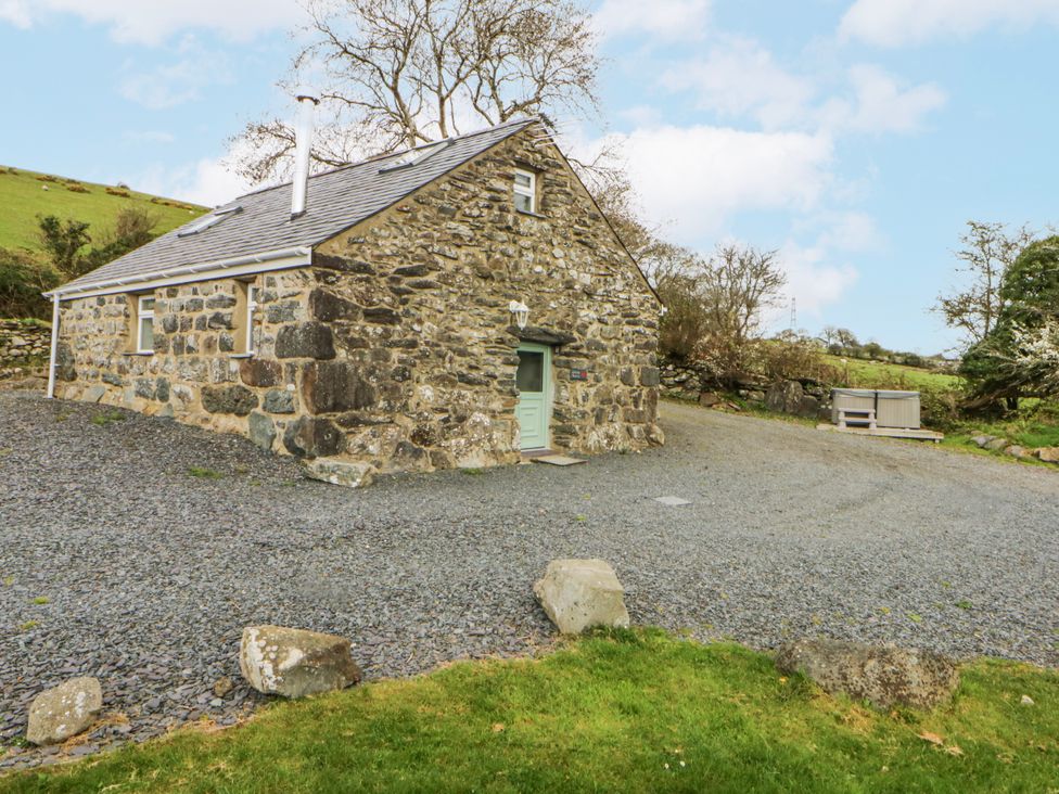 A stone house with gravel path and outdoor area at Little Barn near Criccieth
