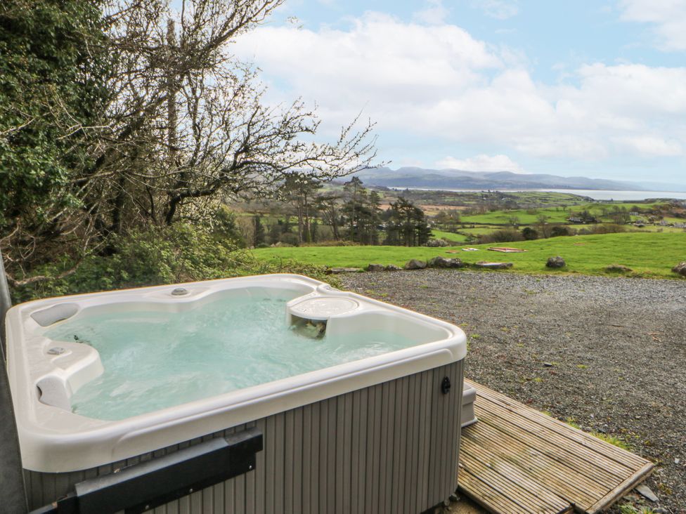 A hot tub overlooking a landscape at Little Barn near Criccieth