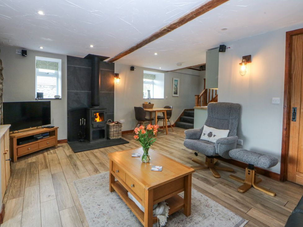 A living room with a television and wood stove at Little Barn near Criccieth