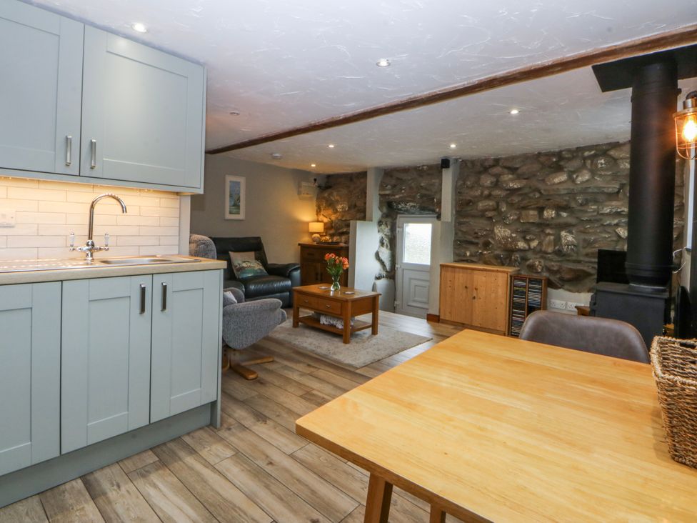 A kitchen and living room area with a dining table at Little Barn near Criccieth