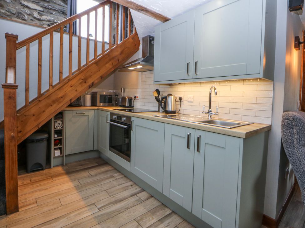 A kitchen with cabinets and appliances at Little Barn near Criccieth