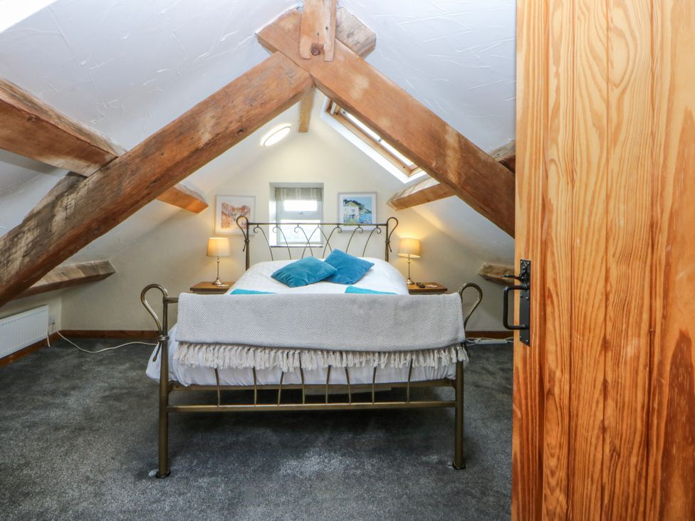A bedroom with a bed and lamp at Little Barn near Criccieth