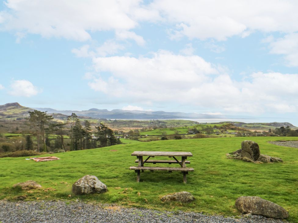 A picnic table on grass with mountains in the background at Little Barn near Criccieth